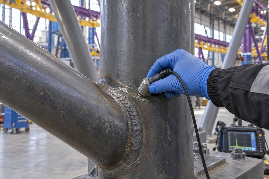 Inspector performing ultrasonic testing on a welded joint
