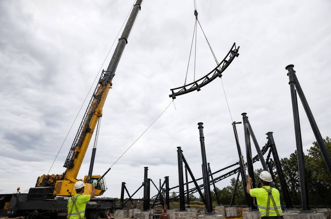 Crane lifting a track section high above support columns